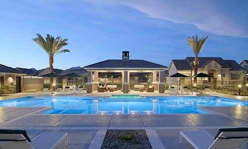 pool with seating and palm trees at dusk